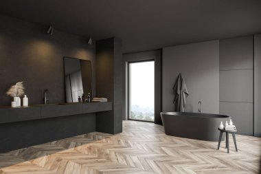Küveti ve lavabosu olan koyu gri banyo köşesi.