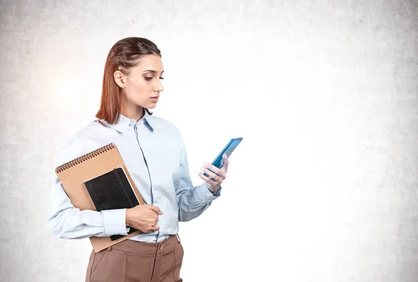 Женщина со смартфоном и блокнотом, макет — стоковое фото