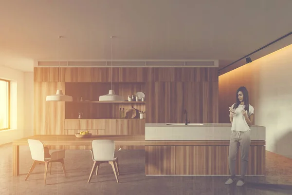 Woman in wooden kitchen with table — Stock Photo, Image