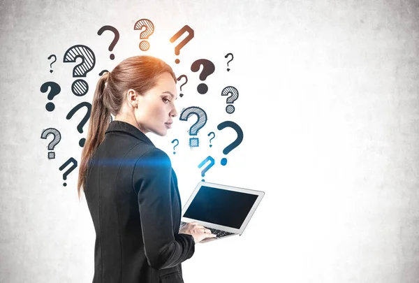 Businesswoman with laptop and question marks — Stock Photo, Image