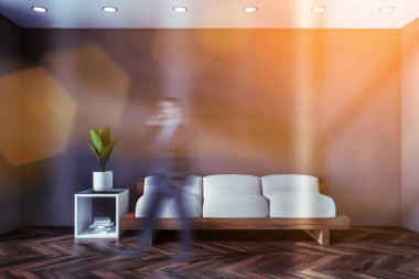 Gri oturma odasında koltuğu olan bir adam.