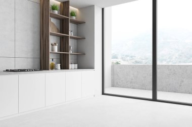 Tezgahı ve balkonu olan beyaz mutfak köşesi.