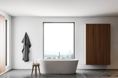 Küvet ve dolapla dolu beyaz banyo.