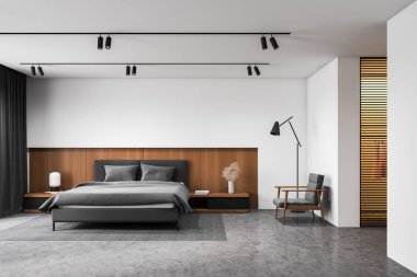 Beyaz ve ahşap ana yatak odası ve koltuk.