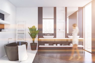 Beyaz ve mavi fayanslı banyoda yürüyen kadın.