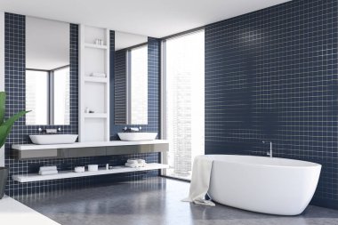 Küveti ve lavabosu olan mavi fayanslı banyo köşesi.