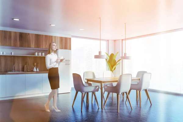 Vrouw in witte en houten keuken met tafel — Stockfoto