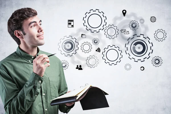 Smiling man with notebook and gears — Stock Photo, Image