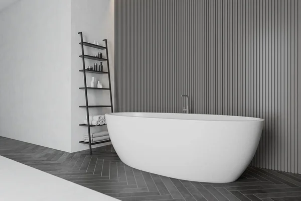 Graue Badezimmerecke mit Badewanne und Regalen — Stockfoto