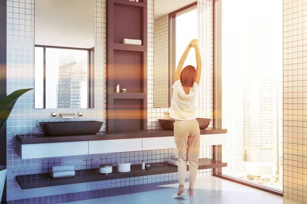 Vrouw in witte tegel badkamer met wastafel — Stockfoto
