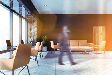 Gri ofis bekleme odasında yürüyen bir işadamı.