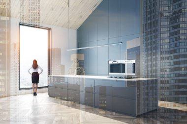 Tavan arası gri mutfak köşesinde adalı bir kadın.