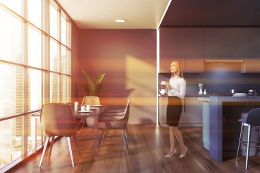 Gri mutfak içindeki sarışın kadın.