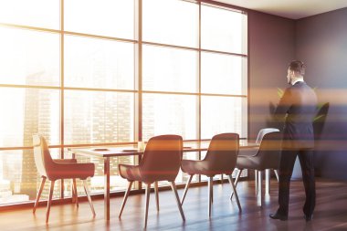 Masası olan gri yemek odasındaki adam.