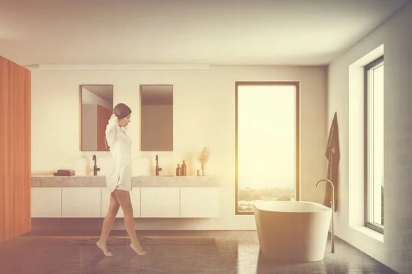 Beyaz banyoda küvetli ve lavabolu bir kadın. — Stok fotoğraf