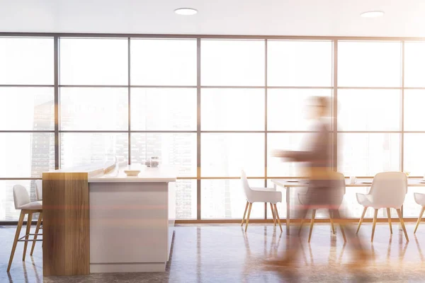 Чоловік ходить на панорамній кухні з білим баром — стокове фото