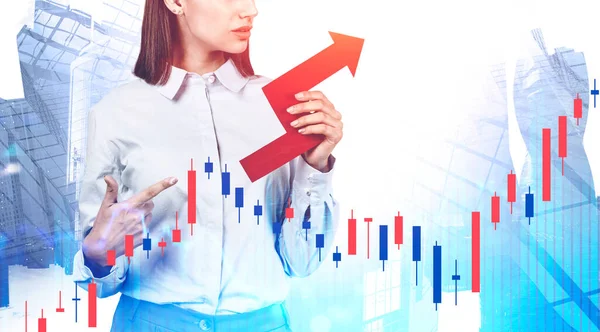 Unrecognizable young businesswoman pointing at red growing business chart standing over cityscape background. Double exposure of forex graph. Concept of financial growth and stock market. Toned image