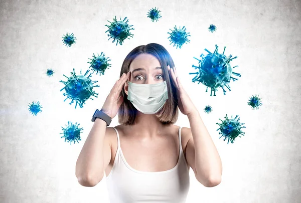 Scared young woman in protective mask standing near concrete wall with blue viruses around her. Concept of coronavirus Asian flu panic