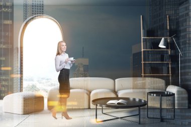 Kahveli gülümseyen sarışın kadın modern oturma odasında gri duvarları, beton zemini, kemerli penceresi ve rahat beyaz koltuğu olan kitaplığı ve masaları olan. Renkli resim çift pozlama