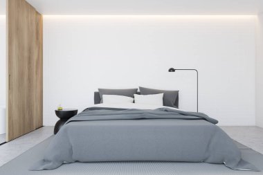 Minimalist yatak odasının içinde beyaz duvarlar, beton zemin, gri battaniyeli ve komodinli komodinli rahat kral yatağı. Tahta sürgülü kapı. 3d oluşturma