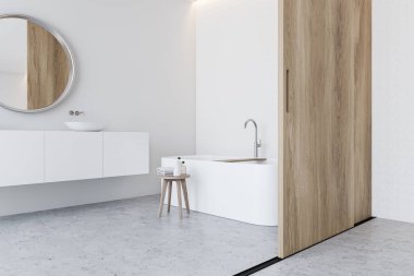 Beyaz duvarları, taş zemini, rahat küveti olan geniş bir banyonun köşesi ve yuvarlak aynalı ve sürgülü kapılı beyaz tezgahta lavabo. 3d oluşturma