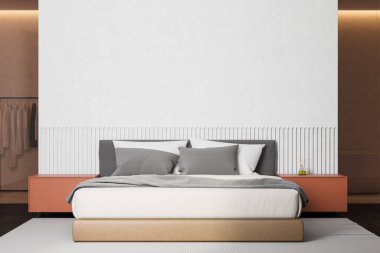 Beyaz duvarları, ahşap zemini, turuncu komodinli ve tuvaletli rahat kral yatağı ve arka planda dolaba inşa edilmiş şık bir yatak odası. 3d oluşturma