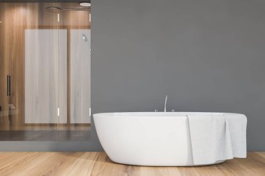 Gri ve ahşap duvarları, rahat küveti ve cam kapılı duş kabini olan şık bir banyo. Spa konsepti. 3d oluşturma