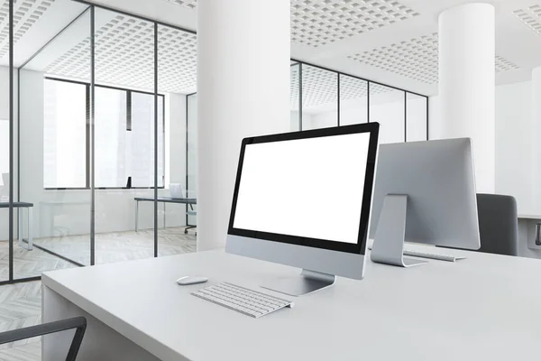 Stylish white open space office interior with mock up computer screen standing on white table. Concept of marketing and advertising. 3d rendering