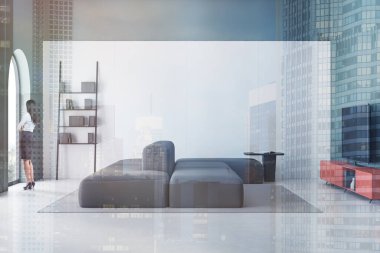 Geniş oturma odasında yeşil ve beyaz duvarları, kemerli pencereleri, rahat kanepesi ve turuncu dolabında modern televizyonu olan genç bir iş kadını. Renkli resim çift pozlama