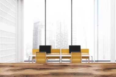 Ürününüzün içi bulanık beyaz duvarları, ahşap zemini, beyaz bilgisayar masaları ve parlak sarı sandalyeleri olan panoramik açık uzay ofisinin masası. Reklam kavramı. 3D oluşturma maketi