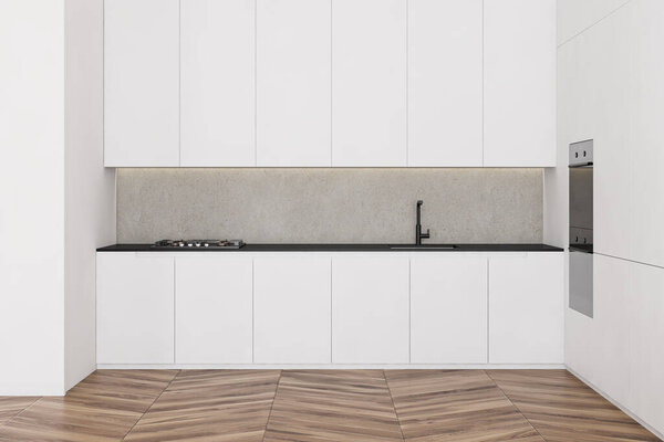 Interior of minimalistic kitchen with white and concrete walls, wooden floor, white countertops and cupboards with built in appliances. 3d rendering