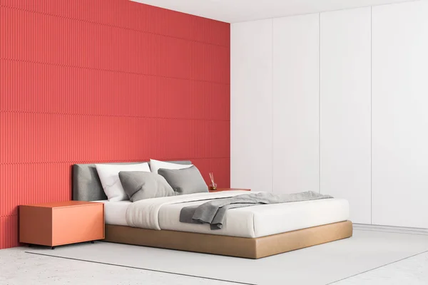 Corner of stylish minimalistic master bedroom with red and white walls, concrete floor, comfortable king size bed and orange bedside tables. 3d rendering