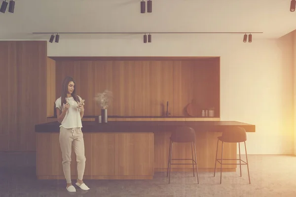 Mujer Joven Con Teléfono Inteligente Pie Cocina Iluminada Por Sol —  Fotos de Stock