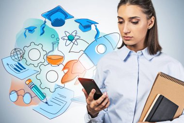Üzerinde renkli bir çizim olan gri duvarın yanında duran telefon ve defterleri olan ciddi, koyu renk saçlı genç bir kadın. Bilgi ve bilim kavramı.