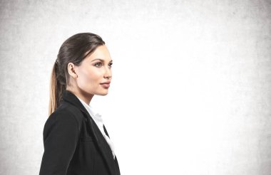 Beton duvarın yanında duran uzun sarı saçlı güzel Avrupalı iş kadınının portresi. Planlama ve iş stratejisi kavramı. Model