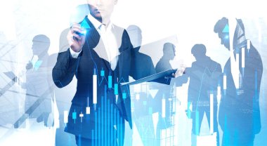 İş dünyasının lideri, arka planda meslektaşlarının siluetlerini kullanarak şehirde finansal grafik arayüzü kullanıyor. Ticaret ve takım çalışması kavramı. Renkli resim çift pozlama
