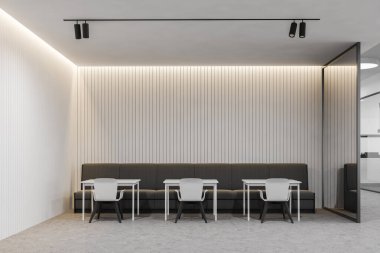 Minimalist ofis kafesinin içinde beyaz duvarlar, beton zemin, beyaz sandalyeli sıra sıra kare masalar ve rahat gri kanepe. 3d oluşturma