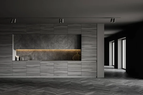 Interior of spacious loft kitchen with grey walls, dark wooden floor, comfortable wooden countertops with built in cooker and sink and dark grey cupboards. 3d rendering
