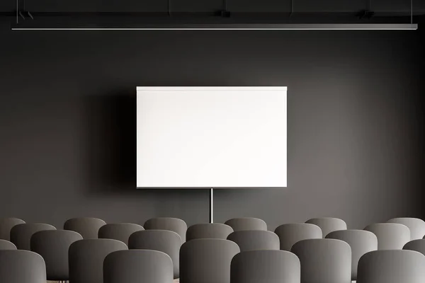 Mock up projection screen in modern office or classroom with dark grey walls and rows of gray chairs. Concept of management and business education. 3d rendering