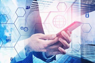 Tanımlanamayan iş adamı gökdelenlerin arka planında akıllı telefon kullanıyor ve bulanık ağ arayüzünü iki kez gösteriyor. İnternet ve iletişim kavramı. Tonu ayarlanmış resim