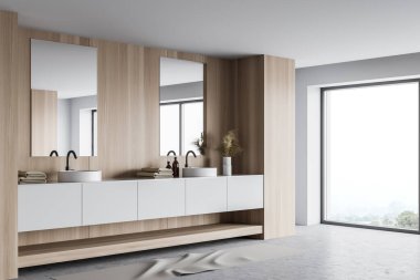 Beyaz ve ahşap duvarları olan şık bir banyonun köşesi, beton zemin, çift yuvarlak lavabo dikey aynaları olan beyaz tezgahın üzerinde duruyor. Bulanık dağ manzaralı bir pencere. 3d oluşturma
