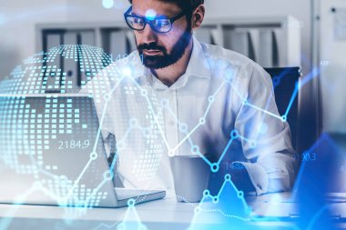 Bulanık ofiste dizüstü bilgisayar kullanan, gözlüklü genç tüccar. Finansal haritaya ve gezegen hologramına iki kez maruz kalmış. Çorap pazarı ve internet kavramı. Tonu ayarlanmış resim
