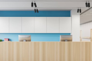 Ahşap resepsiyon masasını kapatın. Bilgisayarlar modern hastane koridorunda, beyaz ve mavi duvarlı ve ahşap kapılı. Sağlık hizmetleri kavramı. 3d oluşturma