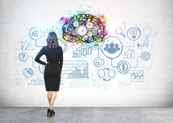 カラフルな脳のスケッチや具体的な壁に描かれたビジネスアイコンを見て長い波状の髪を持つビジネス女性の後部ビュー ブレインストーミングと計画の概念 — ストック写真