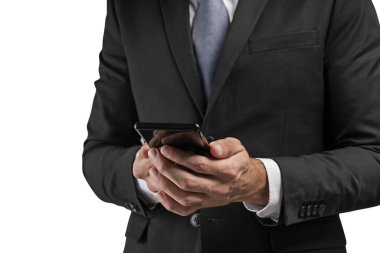 Tanımlanamayan bir iş adamının iki eliyle akıllı telefonu tutarken çekilmiş bir portresi. İnternet ve iletişim kavramı