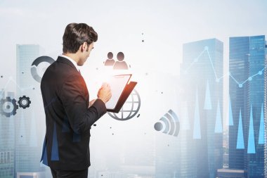 Soyut kentteki panoya internet simgelerinin iki kez gösterildiği iş adamlarının arka görünümü. Teknoloji ve iletişim kavramı. Tonu ayarlanmış resim