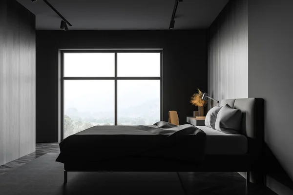 Side view of stylish master bedroom with grey and dark wooden walls, comfortable king size bed, table in home office area and window with blurry mountain view. 3d rendering