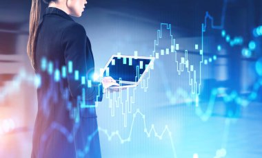 Genç kadın tüccar ofiste dizüstü bilgisayar kullanıyor ve bulanık mali tablolara iki kez maruz kalıyor. Borsa ve yatırım kavramı. Tonu ayarlanmış resim