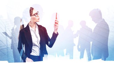Gözlüklü genç Avrupalı iş kadını. Bulanık bir şehirde akıllı telefonunu kullanıyor. Meslektaşlarının iki katına çıkıyor. Liderlik ve iletişim kavramı. Tonu ayarlanmış resim