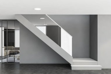 Gri duvarları, beton zemini ve arka planda kahve masası olan beyaz kanepesi olan modern oturma odasında rahat beyaz ve gri merdivenler. 3d oluşturma